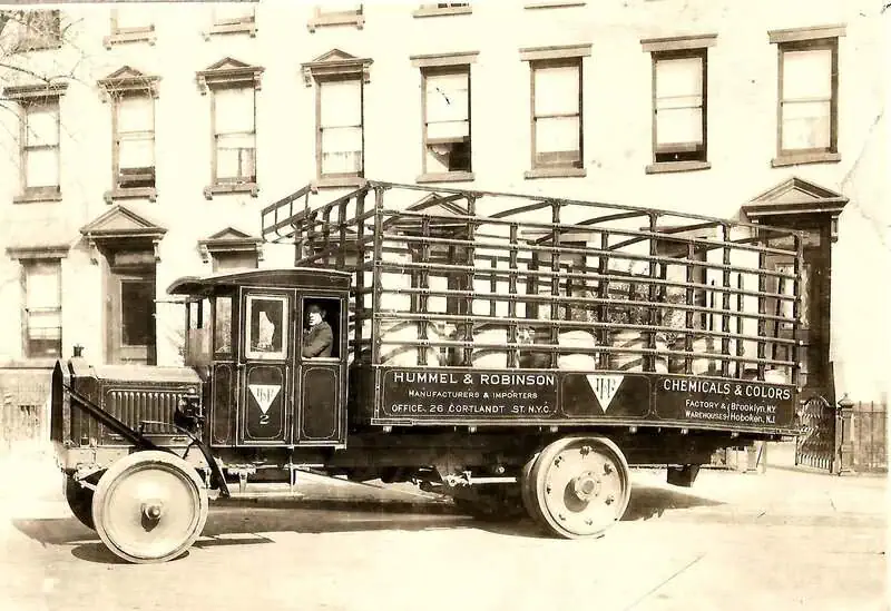 Historic delivery truck labeled Hummel & Robinson Chemicals & Colors parked on a city street in 1913.