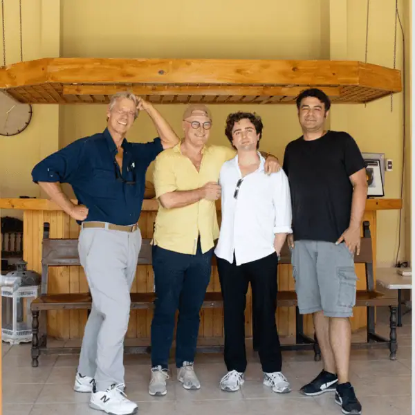 Four men in casual clothing standing indoors after a collaborative organic cotton meeting.