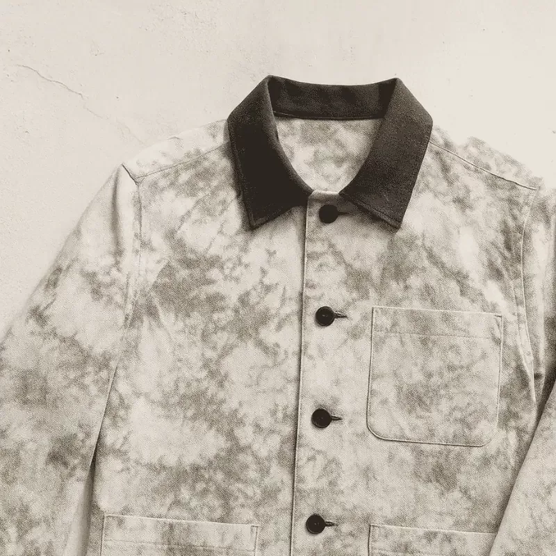 Full view of marbled beige and white jacket with brown collar on light wall